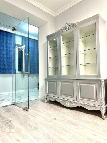 a glass shower in a room with a gray cabinet at Guest House Gayane in Gyumri