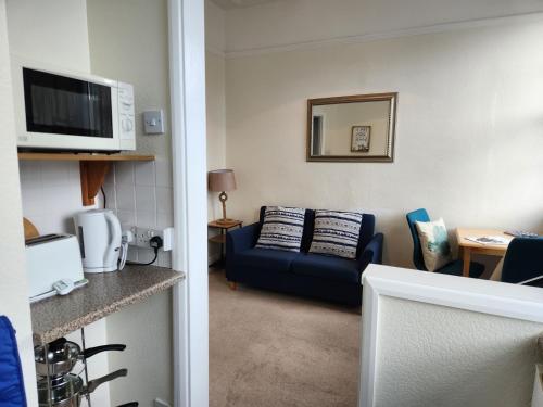 a living room with a couch and a microwave at Rose Court Holiday Apartments in Torquay