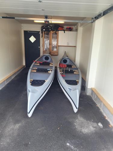 two boats are sitting in a garage at Ferienhaus Kronenpark, Angelcamp mit Angelboot, Kanus, Fahrräder, Jakuzzi, uvm. in Bromölla