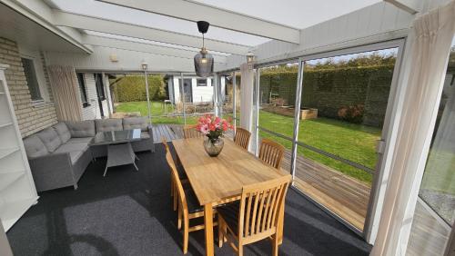a screened in porch with a wooden table and chairs at Ferienhaus Kronenpark, Angelcamp mit Angelboot, Kanus, Fahrräder, Jakuzzi, uvm. in Bromölla