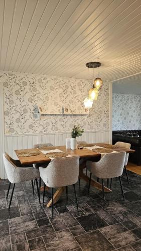 a dining room with a wooden table and chairs at Ferienhaus Kronenpark, Angelcamp mit Angelboot, Kanus, Fahrräder, Jakuzzi, uvm. in Bromölla