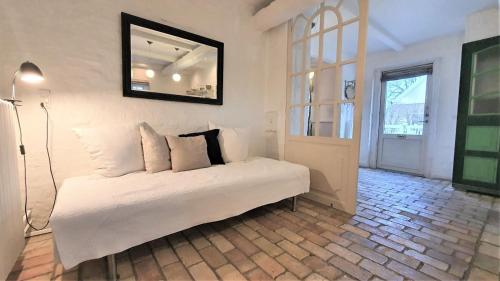 a bedroom with a bed with a mirror on the wall at Store Ejlstrup Bed & Breakfast in Odense