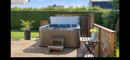 a hot tub and a chair on a wooden deck at Ferienhaus Kronenpark, Angelcamp mit Angelboot, Kanus, Fahrräder, Jakuzzi, uvm. in Bromölla