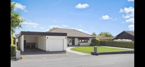 ein Haus mit einer weißen Garage und einer Auffahrt in der Unterkunft Ferienhaus Kronenpark, Angelcamp mit Angelboot, Kanus, Fahrräder, Jakuzzi, uvm. in Bromölla