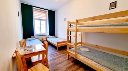 a room with two bunk beds and a table at Noclegi Pan Tadeusz in Wałbrzych