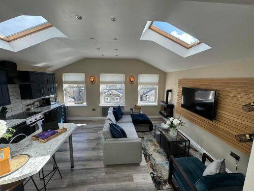 a living room with a couch and a kitchen with skylights at Apartment in North Yorkshire (Crosshills) in Kildwick