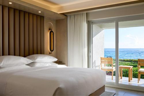 a bedroom with a bed and a view of the ocean at JW Marriott St Maarten Beach Resort & Spa in Dawn Beach