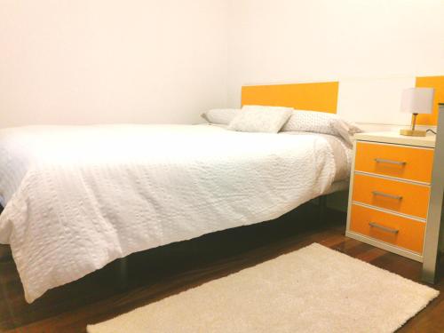 una camera con letto bianco e comodino di Habitación cerca del aeropuerto a Maliaño