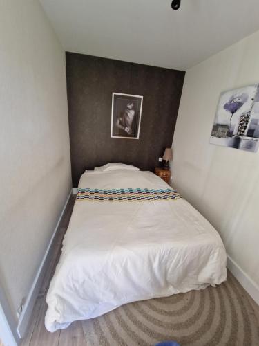 une chambre avec un lit blanc dans une pièce dans l'établissement Les voiles de la Baule, à La Baule