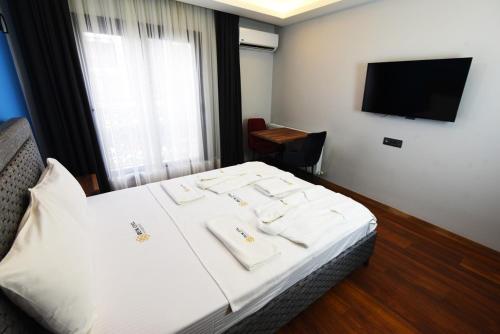 Habitación de hotel con cama y TV en Renk Otel Karşıyaka, en Karşıyaka