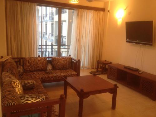 a living room with two couches and a television at Bamburi Beach Homes in Bamburi