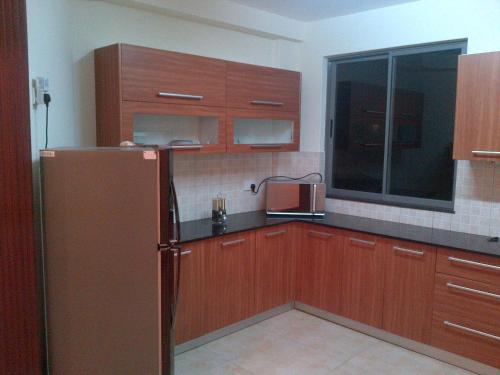 a kitchen with wooden cabinets and a refrigerator at Bamburi Beach Homes in Bamburi