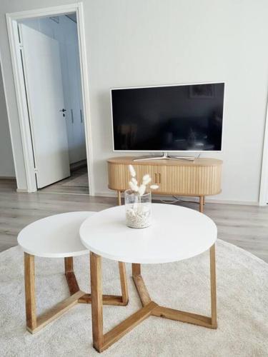 a living room with a white table and a tv at Villa Kaisla in Raahe