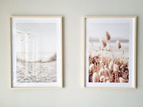 two framed photographs hanging on a white wall at Villa Kaisla in Raahe