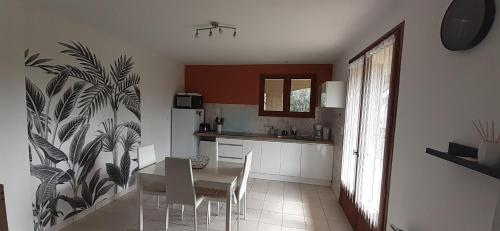 une cuisine avec une table et des chaises dans une pièce dans l'établissement L'Escapade T2 avec Piscine et Jardin, à Saint-Privat