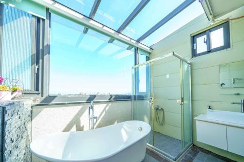 a bathroom with a glass shower and a tub at 宜蘭幸福8號主題寵物友善民宿 in Wujie