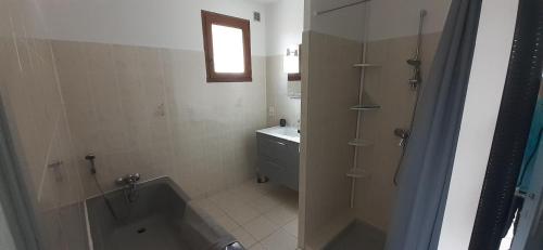 une salle de bain avec une baignoire et un lavabo dans l'établissement L'Escapade T2 avec Piscine et Jardin, à Saint-Privat