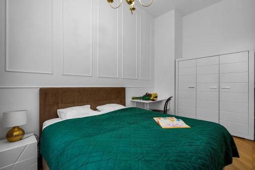 a bedroom with a green bed and white cabinets at Luxury Apartment next to Koszykowa Street in Warsaw