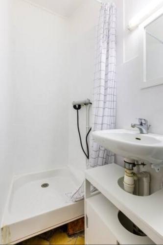 une salle de bain blanche avec un lavabo et un miroir dans l'établissement ++++ STUDIO AVEC JARDIN A 200 M DE LA MER ET 300 M RUE PIETONNE ++++, à Berck-sur-Mer