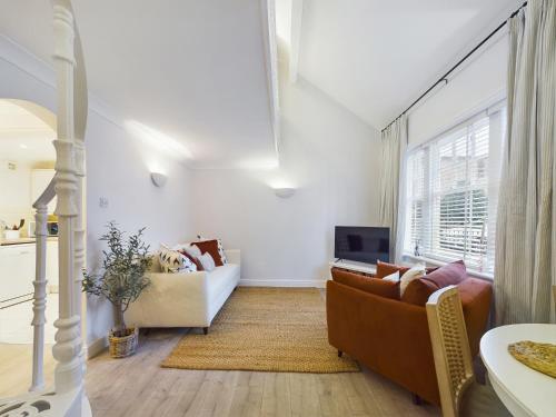 uma sala de estar com dois sofás e uma televisão em “The Sleepers Cottage” 2-6 people w/ free parking em Hough Green