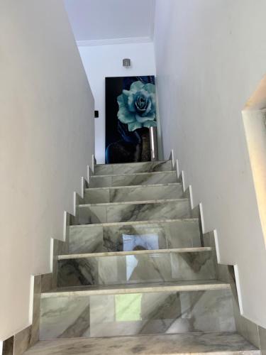 una escalera con una flor azul en un jarrón en Casa de Praia Barra Itanhangá, en Río de Janeiro