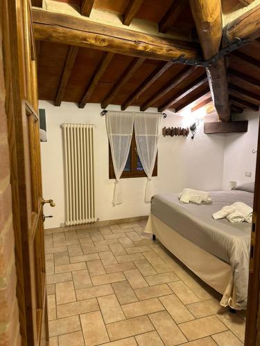 a bedroom with a bed and a tile floor at Il Nido di Fede e Romy in Castelnuovo Berardenga