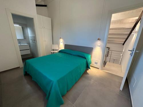 a bedroom with a green bed and a bathroom at Scopello - Finestra sul cortile in Scopello