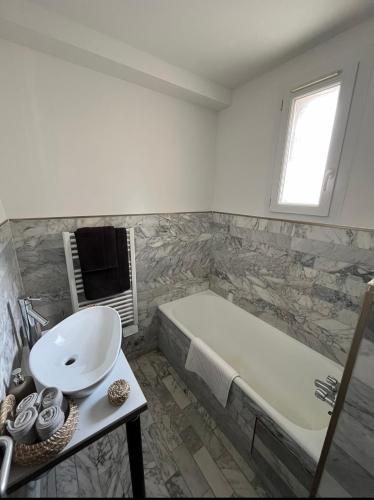 une salle de bain avec un lavabo et une baignoire dans l'établissement Bienvenue chez vous !, à Ajaccio