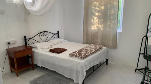 a bedroom with a bed and a table and a window at Palm Creek Villa in Mont Choisy