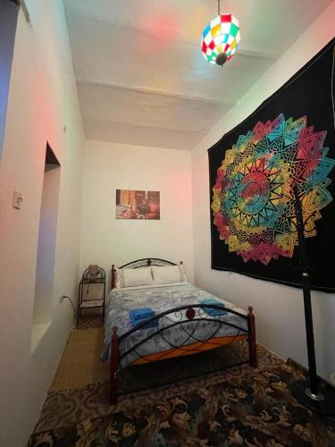 a bedroom with a bed and a painting on the wall at Dar Mora in Tangier