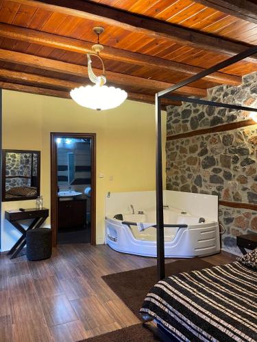 a bedroom with a bed and a tub in a room at Gioras Hotel in Palaios Agios Athanasios