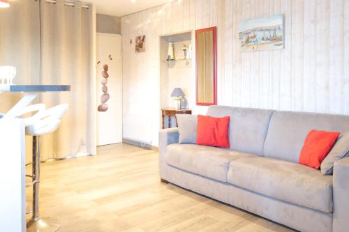 uma sala de estar com um sofá azul com almofadas vermelhas em Studio à 100m de la grande plage des Sables d'Olonne - 2 pers em Les Sables-dʼOlonne