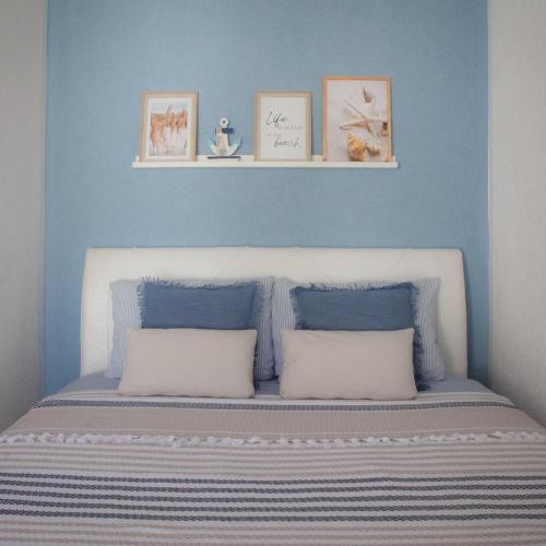 a blue bedroom with a bed with two pillows at Apartman Harmony in Sutomore