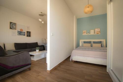 ein Schlafzimmer mit einem Bett und einem Sofa in der Unterkunft Apartman Harmony in Sutomore