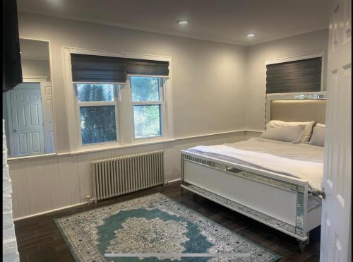 a bedroom with a bed and two windows at Private Suite In Huntington Station in Huntington Station