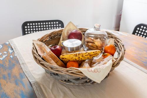 a basket of fruit and a bottle on a table at B&B Agriturismo La Casetta di Ben in Viterbo