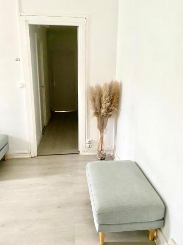 Cette chambre dispose d'un pouf et d'un vase avec des plumes. dans l'établissement Appartement de 3 chambres, à Ris-Orangis