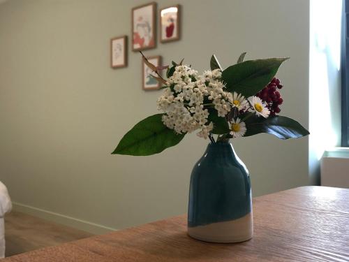 a vase filled with flowers sitting on a table at Le 270 in Grane