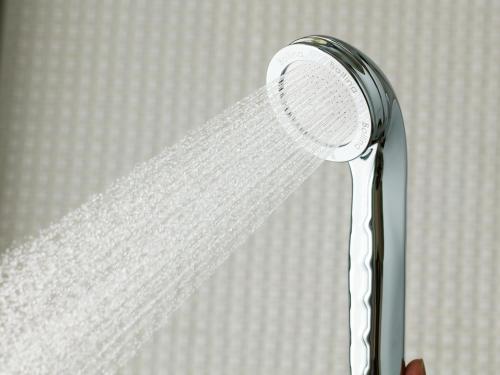 głowicę prysznicową z wodą płynącą z niej w obiekcie APA Hotel & Resort Osaka Umeda-eki Tower w Osace