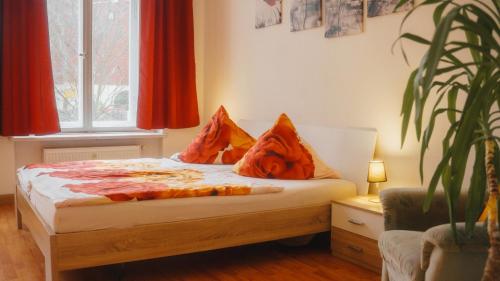 ein Schlafzimmer mit einem Bett mit orangefarbenen Kissen darauf in der Unterkunft Sylvias Ferienwohnung Nr2 in Görlitz