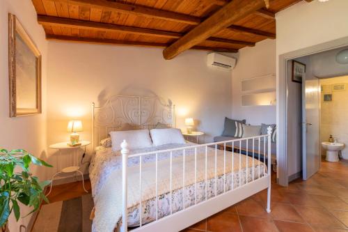 1 dormitorio con cama blanca y techo de madera en B&B Agriturismo La Casetta di Ben, en Viterbo