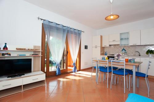a kitchen and dining room with a table and chairs at Villetta Alcumissa in San Teodoro