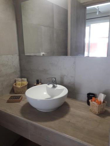 a bathroom with a white sink and a mirror at Spedion Kefallonia in Pesádha