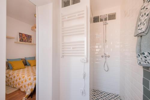 Elle comprend un lit et une salle de bains blanche pourvue d'une douche. dans l'établissement Brand new stylish ,spacious and cosy room with en suite bathroom, à Madrid