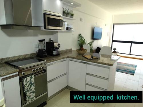 a kitchen with a stove and a counter top at Apart. con aire, frente al mar in Porlamar