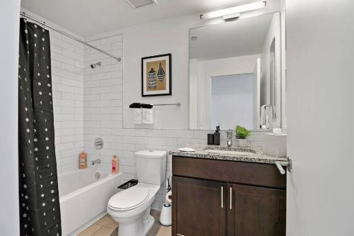 2BR Stylish Apartment in Hyde Park - Shoreland 1320 في شيكاغو: حمام مع مرحاض ومغسلة وحوض استحمام