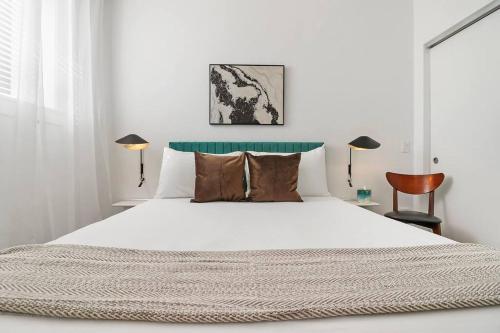 1 dormitorio con 1 cama blanca grande y 2 lámparas en Stylish 2BR Retreat in Hyde Park - Shoreland 1320, en Chicago