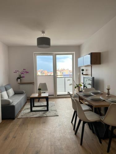 a living room with a table and a couch at Apartament Browarna in Nowy Sącz