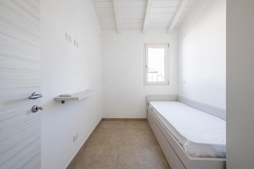 a white room with a bed and a window at Appartamento Luxury vista mare in Lido di Camaiore