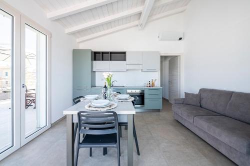 a kitchen and living room with a table and a couch at Appartamento Luxury vista mare in Lido di Camaiore